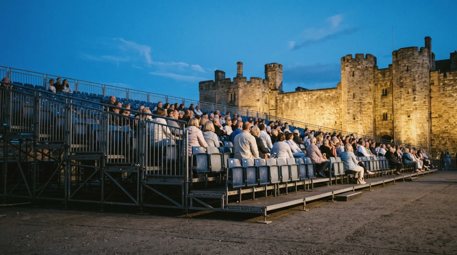Massed pipes and drums on the floodlit castle esplanade seen from the stands, the view a Royal Edinburgh Military Tattoo ticket buys