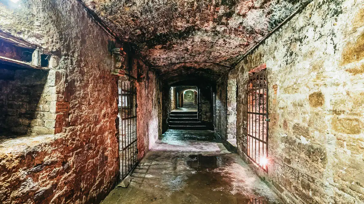 Torture exhibition display lit by lamplight on a late-night Edinburgh underground vaults terror tour