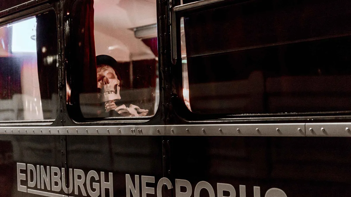 Black vintage double-decker Ghost Bus parked on George IV Bridge for a comedy horror ghost bus tour in Edinburgh